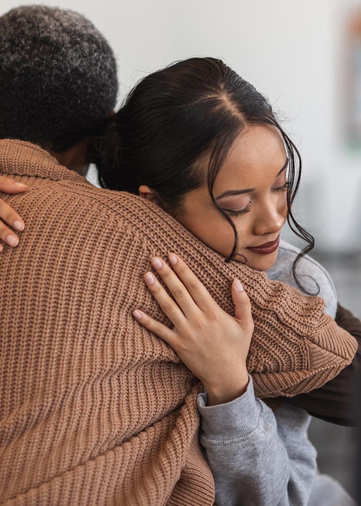 women hugging in a domestic violence support group