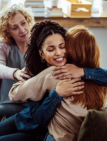 women hugging in a support group